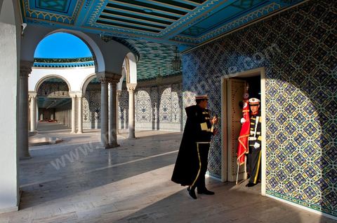 12 mars : dans la cour, les gardes présidentiels se préprarent pour la cérémonie hebdomadaire du drapeau au Palais Présidentiel de Carthage, le président de la République a présidé une cérémonie de lever du drapeau tunisien. Au cours de cette cérémonie, Moncef Marzouki a décoré l'étudiante Khaoula Rchidi et lancé un message à toute personne qui touche au drapeau " symbole d’un peuple musulman ". La semaine dernière a été marquée par les incidents qui ont eu lieu à la faculté de la Mannouba. La jeune étudiante, Khaouala Rchidi, décorée de l'ordre de la République, était émue : "Je n’ai pas réfléchi, je regardais ce qu’il était en train de faire et j’ai tout de suite réagi. Je suis gafsienne et j'ai le sang chaud. C'est peut être pour cela que j'ai intervenu. Notre drapeau est cher, il ne faut pas ne négliger". Après le discours, l'hymne national a été chanté avec beaucoup d'émotion par les personnes présentes. Khaoula Rchidi a ensuite été accueillie dans le salon doré et décorée par le président : "Ce qu'elle a fait est exceptionnel, elle a défendu la Tunisie. C'était la force morale face à la force physique" a-t-il avoué. L'étudiante membre de l'UGET, Amel Aloui, qui a été agressée durant les incidents de la faculté de la Mannouba, a également rencontré Moncef Marzouki et a été applaudie par les présents.