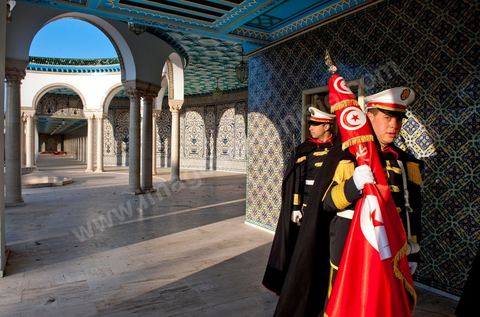 12 mars : dans la cour, les gardes présidentiels se préprarent pour la cérémonie hebdomadaire du drapeau au Palais Présidentiel de Carthage, le président de la République a présidé une cérémonie de lever du drapeau tunisien. Au cours de cette cérémonie, Moncef Marzouki a décoré l'étudiante Khaoula Rchidi et lancé un message à toute personne qui touche au drapeau " symbole d’un peuple musulman ". La semaine dernière a été marquée par les incidents qui ont eu lieu à la faculté de la Mannouba. La jeune étudiante, Khaouala Rchidi, décorée de l'ordre de la République, était émue : "Je n’ai pas réfléchi, je regardais ce qu’il était en train de faire et j’ai tout de suite réagi. Je suis gafsienne et j'ai le sang chaud. C'est peut être pour cela que j'ai intervenu. Notre drapeau est cher, il ne faut pas ne négliger". Après le discours, l'hymne national a été chanté avec beaucoup d'émotion par les personnes présentes. Khaoula Rchidi a ensuite été accueillie dans le salon doré et décorée par le président : "Ce qu'elle a fait est exceptionnel, elle a défendu la Tunisie. C'était la force morale face à la force physique" a-t-il avoué. L'étudiante membre de l'UGET, Amel Aloui, qui a été agressée durant les incidents de la faculté de la Mannouba, a également rencontré Moncef Marzouki et a été applaudie par les présents.