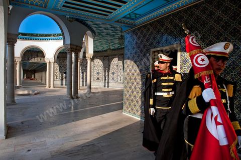 12 mars : dans la cour, les gardes présidentiels se préprarent pour la cérémonie hebdomadaire du drapeau au Palais Présidentiel de Carthage, le président de la République a présidé une cérémonie de lever du drapeau tunisien. Au cours de cette cérémonie, Moncef Marzouki a décoré l'étudiante Khaoula Rchidi et lancé un message à toute personne qui touche au drapeau " symbole d’un peuple musulman ". La semaine dernière a été marquée par les incidents qui ont eu lieu à la faculté de la Mannouba. La jeune étudiante, Khaouala Rchidi, décorée de l'ordre de la République, était émue : "Je n’ai pas réfléchi, je regardais ce qu’il était en train de faire et j’ai tout de suite réagi. Je suis gafsienne et j'ai le sang chaud. C'est peut être pour cela que j'ai intervenu. Notre drapeau est cher, il ne faut pas ne négliger". Après le discours, l'hymne national a été chanté avec beaucoup d'émotion par les personnes présentes. Khaoula Rchidi a ensuite été accueillie dans le salon doré et décorée par le président : "Ce qu'elle a fait est exceptionnel, elle a défendu la Tunisie. C'était la force morale face à la force physique" a-t-il avoué. L'étudiante membre de l'UGET, Amel Aloui, qui a été agressée durant les incidents de la faculté de la Mannouba, a également rencontré Moncef Marzouki et a été applaudie par les présents.