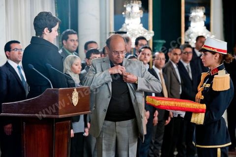 March 12: Moncef Marzouki pinned a Tunisian flag pin on young student Khaoula Rchidi at the Presidential Palace in Carthage; the President of the Republic presided over a Tunisian flag-raising ceremony. During the ceremony, Moncef Marzouki awarded a decoration to student Khaoula Rchidi and issued a message to anyone who desecrates the flag, “a symbol of a Muslim people.” Last week was marked by incidents that took place at the University of Mannouba. The young student, Khaoula Rchidi, who was awarded the Order of the Republic, was moved: “I didn’t think twice; I saw what he was doing and reacted immediately. I’m from Gafsa and I’m hot-blooded. Maybe that’s why I stepped in. Our flag is precious; we must not take it for granted.” After the speech, the national anthem was sung with great emotion by those present. Khaoula Rchidi was then welcomed into the Golden Room and honored by the president: “What she did was exceptional; she defended Tunisia. It was moral strength against physical force,” he acknowledged. Amel Aloui, a student and member of the UGET who was assaulted during the incidents at the Mannouba Faculty, also met with Moncef Marzouki and was applauded by those present.

