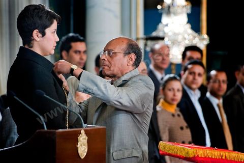 March 12: Moncef Marzouki pinned a Tunisian flag pin on young student Khaoula Rchidi at the Presidential Palace in Carthage; the President of the Republic presided over a Tunisian flag-raising ceremony. During the ceremony, Moncef Marzouki awarded a decoration to student Khaoula Rchidi and issued a message to anyone who desecrates the flag, “a symbol of a Muslim people.” Last week was marked by incidents that took place at the University of Mannouba. The young student, Khaoula Rchidi, who was awarded the Order of the Republic, was moved: “I didn’t think twice; I saw what he was doing and reacted immediately. I’m from Gafsa and I’m hot-blooded. Maybe that’s why I stepped in. Our flag is precious; we must not take it for granted.” After the speech, the national anthem was sung with great emotion by those present. Khaoula Rchidi was then welcomed into the Golden Room and honored by the president: “What she did was exceptional; she defended Tunisia. It was moral strength against physical force,” he acknowledged. Amel Aloui, a student and member of the UGET who was assaulted during the incidents at the Mannouba Faculty, also met with Moncef Marzouki and was applauded by those present.

