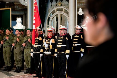 March 12: In the ceremonial hall, members of the Tunisian security forces took their places for the ceremony. At the Presidential Palace in Carthage, the President of the Republic presided over a Tunisian flag-raising ceremony. During the ceremony, Moncef Marzouki awarded a medal to student Khaoula Rchidi and issued a message to anyone who defiles the flag, “a symbol of the Muslim people.” Last week was marked by the incidents that took place at the University of Mannouba. The young student, Khaoula Rchidi, who was awarded the Order of the Republic, was moved: “I didn’t think twice; I saw what he was doing and reacted immediately. I’m from Gafsa and I’m hot-blooded. Maybe that’s why I stepped in. Our flag is precious; we must not take it for granted.” After the speech, those present sang the national anthem with great emotion. Khaoula Rchidi was then welcomed into the Golden Room and honored by the president: “What she did was exceptional; she defended Tunisia. It was moral strength against physical force,” he acknowledged. Amel Aloui, a student and member of the UGET who was assaulted during the incidents at the University of Mannouba, also met with Moncef Marzouki and was applauded by those present.

