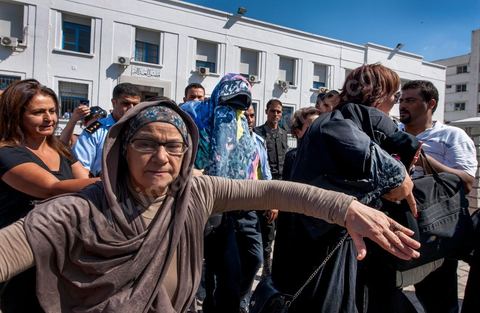 2 octobre 2012 : Sortie des jeunes fiancés de Tunis, la femme violée sous un voile noir et dans les brasp de son avocate et le fiancé sous une serviette pour préserver l'anonymat de ce jeune couple victime de la police après leur passage chez le juge ce matin. La femme violée par des policiers et son fiancé ont été interrogée ce matin par un juge d'instruction de Tunis qui doit décider de l'inculper ou non d'"atteinte à la pudeur". A l'issue d'un interrogatoire de plus de deux heures mené par Mohamed Ben Meftah, les avocats de la victime se sont dits "optimistes" quant à l'abandon des poursuites contre leur cliente et son fiancé pour ce délit passible de six mois de prison. Le juge d'instruction doit décider dans les heures ou les jours à venir de "classer l'affaire ou la transférer devant le tribunal compétent".