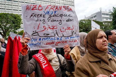 14 janvier 2013 : Militant d'Ennahdha parti islmaiste au pouvoir en Tunisie brandissant des banderolles de protestation contre l'intervention d ela France au Mali. Entre l'avenue Habib Bourguiba et la place du 14 janvier, les tunisiens sont venus commémorer, dans une ambiance politique tendue, le deuxième anniversaire d ela Révolution marqué en 2011 par la fuite de l'ancien président Ben Ali.