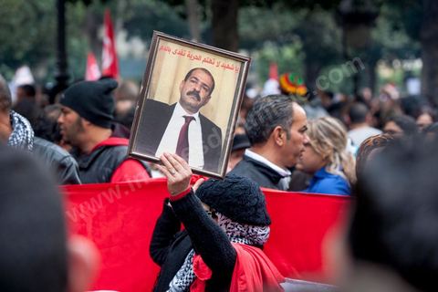 23 février 2013 : la foule brandit le portrait de Chokri Bealid. près de 3000 partisans et citoyens sont venus protester devant le Ministère de l'Intérieur pour la lenteur de l'enquête sur l'assassinat du militant politique Chokri Belaid le 6 février dernier. Les slogans ont aussi accusé le parti au pouvoir Ennahdha et son dirigeant Rached Ghannouchi.