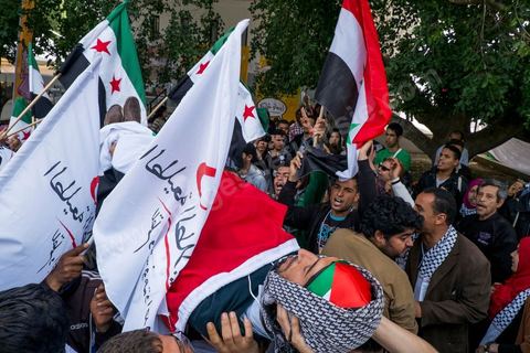 March 29, 2013: A highly tense standoff and minor clashes between pro-rebellion Syrians (three-red-star flag) and Tunisian activists from the pro-Bashar al-Assad Bass Party, with pro-Palestinian demonstrators in the middle brandishing a fake corpse in the central square of the WSF on the final day of the World Social Forum meetings on the Tunis university campus. This first forum held in the Arab world was strongly marked by Arab nationalist demands and observations, and dominated by a constant tribute to and support for the Palestinian people.