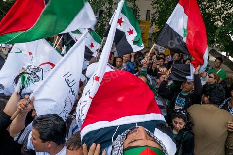 March 29, 2013: A highly tense standoff and minor clashes between pro-rebellion Syrians (three-red-star flag) and Tunisian activists from the pro-Bashar al-Assad Bass Party, with pro-Palestinian demonstrators in the middle brandishing a fake corpse in the central square of the WSF on the final day of the World Social Forum meetings on the Tunis university campus. This first forum held in the Arab world was strongly marked by Arab nationalist demands and observations, and dominated by a constant tribute to and support for the Palestinian people.