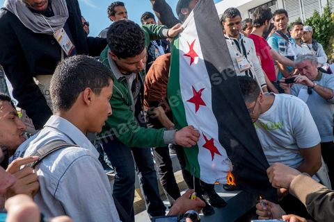 29 mars 2013 : les militants tunisiens du parti Bass pro Bachar El Assad sur la place centrale du FSM brule le drapeau des rebelles syriens au dernier jour des rencontres du Forum Social Mondial sur le campus universitaire de Tunis. Ce premier forum en Terre arabe a été fortement marqué par les revendicatiosn et constatestations nationaliste arabes, et dominé par un hommage et soutien constant au peuple palestinien.