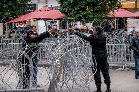 9 avril 2013 : un policier récupère les fusils de chevrotine aux policiers pour les remettre au ministrère de l'Intérieur, dispositif sécuritaire, la police sépare les deux côtés de l'avenue. à l'occasion de la journée des martyrs, l'avenue Bourguiba à Tunis a accueilli plusieurs marches politiques. Entre la première marche de la nouvelle alliance politique "Union pour la Tunisie", regroupant les partis progressistes Nidaa Tounes, Al Joumhouri, Al Massar, Parti Socialiste et Parti Patriotique, et celle des partisans de Ennahdha et des Ligues de Protection de la Révolution (LPR) la tension a été au maximum mais contrôlé par un dispositif sécuritaire impotant et efficace.