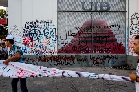 31 juillet 2013 : Tags sur la banque UIB sur la place. depuis 4 soirs, les tunisiois se réunissent sur la place devant l'Assemblée Nationale dans le quartier du Bardo de Tunis. Autour des sitins nocturnes des députés en grève, la population vient manifester son mécontement suite à l'assassinat du député Mohamed Brahmi et des 8 militaires au Jebel Chambi