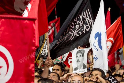 3 août 2013 : un manifestant brandi le portrait du martyr de Mohamed Brahmi, député assasiné la semaine dernière. Plus de 50 000 manifestants à l'appel du parti islamiste au pouvoir Ennahdha grand rassemblement à la place d ela Kasbah à Tunis en réponse aux rassemblements de l'opposition au Bardo suit à l'assassinat du député de gauche Brahmi et des 8 militaires à Chambi.