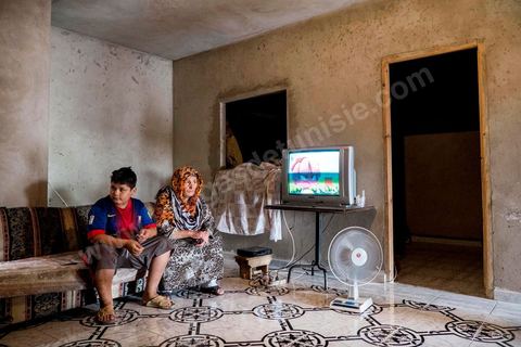 The mother and her second son in their living room. At the home of Ahmed and Janet RIHIME in the Kabaria neighborhood. These parents have been searching for their 19-year-old son, Wissem, since March 2011. The tragedy struck this family twice when Janet, the mother, in a moment of despair, set herself on fire a few months ago.