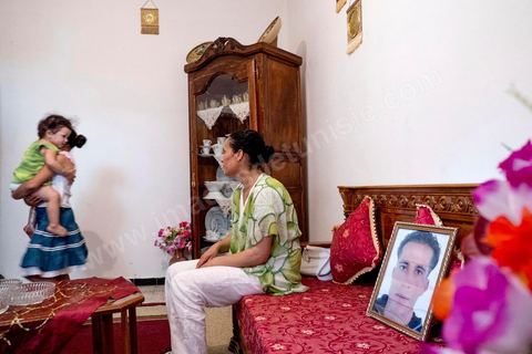 In the living room with her two daughters and a portrait of her missing husband. At Omelkhir Ouiretani’s home, this young mother of two daughters is searching for her husband, Nabil, who went missing on the boat on March 29, 2011, in the Kabaria neighborhood.