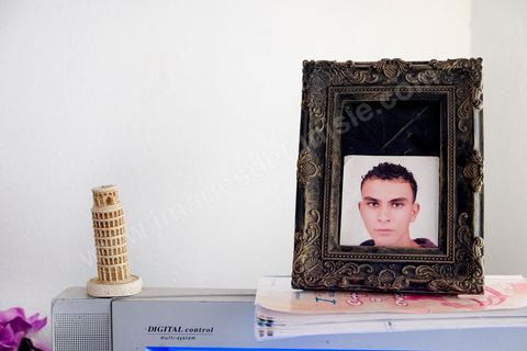 A Kabaria, quartier populaire de la banlieue sud de Tunis, Chez Nourredine MBAREK, père de Karim disparu le 29 mars 2011. Portrait de Karim posé sur la Télé du salon à côté d'une tour de Pise.
