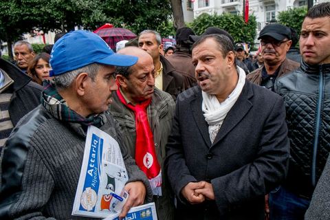 14 janvier 2014 : Samir Taieb arpès de ses militant ssur le stand d'Al Massar sur l'avenue Habib Bourguiba à Tunis quelques milliers de tunisiens sont venus se rassembler pour commémorer le troisième anniversaire du départ de l'ancien Président Ben Ali, aboutissement des mouvements de révoltes en région démarrés le 17 décmbre 2010. Tous les genres politiques se croisent et se chamaillent l'avenue, d'un côté les islamistes avec Ennahdha, les ligues et même un nouveau mouvement islamiste anachiste, de l'autre la gauche et l'opposition commémorant à la fois le départ des anciens et la mémoire des martyrs de la révolution et des martyrs politiques. 