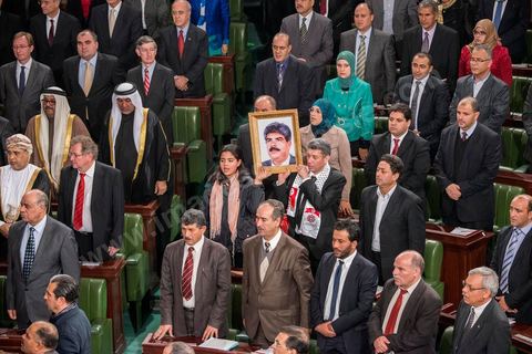 27 janvier 2014 : Cérémonie de signature de la Constitution à l'assemblée constituante, le 27 janvier 2014 en présence de personnalités nationales et internationales. Au centre, la fille du député assassiné le 25 juillet 2013, Mohamed Brahmi, tient un portrait de son père, avec le député Mourad Amdouni.