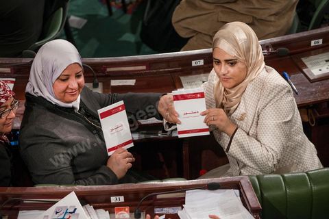 27 janvier 2014 : Deux députées Ennahdha tiennent un exemplaire de la nouvelle constitution. Cérémonie de signature de la Constitution à l'assemblée constituante, le 27 janvier 2014 en présence de personnalités nationales et internationales.