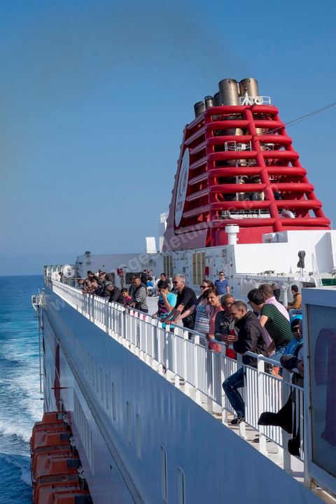 22 au juin 2014 : passagers sur le pont à l'approche de la Tunisie à bord du nouveau navire Tanit de la CTN (Compagnie Tunisienne de Navigation) aller-retour Tunis-Marseille. Le retour des immigrés tunisiens en France chaque été représente une manne touristique et financière très importante pour la Tunisie. Le navire Tanit a été mis en service en 2012, il mesure 212 m de long pour 30 m de large, peut atteindre la vitesse max de 27,5 noeuds, capacité d'accueil 3200 passagers et 1060 véhicules.