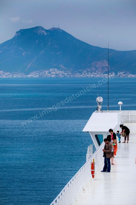 22 au juin 2014 : passagers sur le pont à l'approche de la Tunisie à bord du nouveau navire Tanit de la CTN (Compagnie Tunisienne de Navigation) aller-retour Tunis-Marseille. Le retour des immigrés tunisiens en France chaque été représente une manne touristique et financière très importante pour la Tunisie. Le navire Tanit a été mis en service en 2012, il mesure 212 m de long pour 30 m de large, peut atteindre la vitesse max de 27,5 noeuds, capacité d'accueil 3200 passagers et 1060 véhicules.
