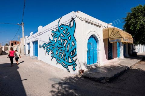 Oeuvres de l'artiste tunisien EL SEED pour le Projet DjerbaHood : après la Tour Paris 13, la team Itinerrance dépose ses valises dans un village traditionnel de l’île de Djerba, Erriadh. Depuis le début du mois de juillet, le village d’Erriadh se métamorphose petit à petit pour devenir un véritable musée à ciel ouvert. Une sélection d’artistes des quatre coins du monde ont été invités à s’exprimer dans ce décor unique à l’architecture authentique : murs blancs, portes bleues turquoises, dômes, veilles constructions et divers lieux abandonnés, autant de possibilités qui donneront naissance à des créations uniques aux couleurs locales.