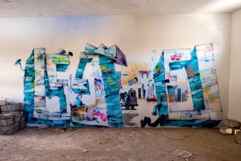 The DjerbaHood Project: After the Tour Paris 13, the Itinerrance team has set up shop in Erriadh, a traditional village on the island of Djerba. Since early July, the village of Erriadh has been gradually transforming into a veritable open-air museum. A selection of artists from around the world has been invited to showcase their work in this unique setting with its authentic architecture: white walls, turquoise-blue doors, domes, old buildings, and various abandoned sites—all offering endless possibilities that will give rise to unique creations imbued with local character.