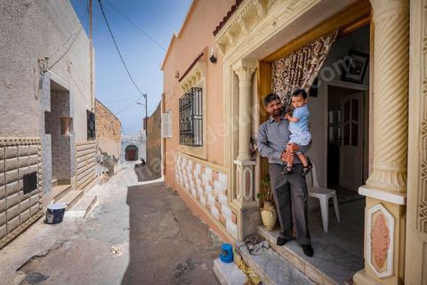 June 24, 2014: Mohamed with his grandson in front of his house in the medina of Ksibet. Mohamed, a fishing boat captain in Ksibet El Mediouni near Monastir, smuggled hundreds of young undocumented migrants between Tunisia and Sicily between 1996 and 2002. Sentenced to six and a half years in prison, he has now returned to his job as a fishing boat captain. 
