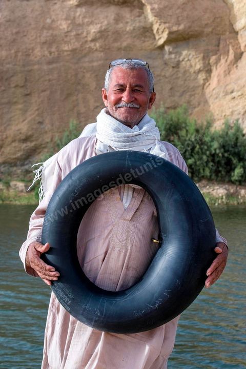 Belgacem came with some friends to go swimming in the lake at "Gafsa Beach." Since he didn't know how to swim, he made a float out of an inner tube.