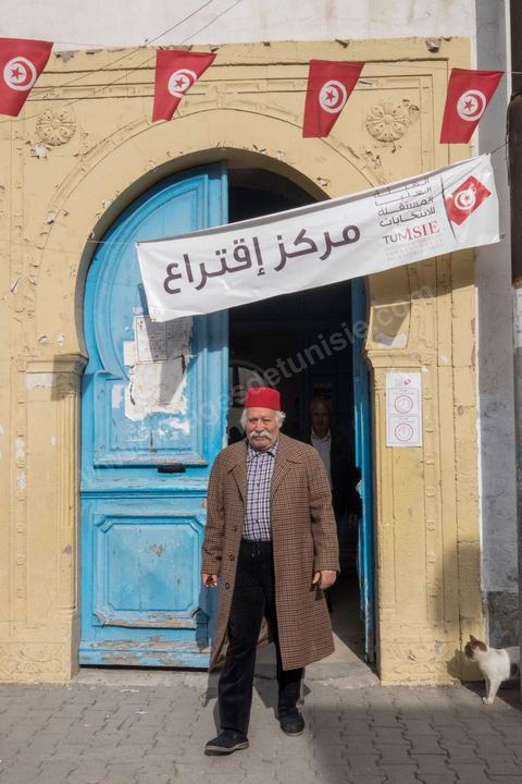 23 novembre 2014 : jour de vote du 1er tour des élections présidentielles. Un ancien militant nationaliste, tailleur de profession, électeur à Bab Souika, tient à montrer chez lui une photo où il est en compagnie de Béji Caid Essebsi, qu'il soutient pour l'élection présidentielle. Il pose également avec la copie de la première carte d'identité nationale délivrée à Habib Bourguiba après l'indépendance.