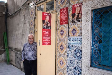 23 novembre 2014 : jour de vote du 1er tour des élections présidentielles. Un ancien militant nationaliste, tailleur de profession, électeur à Bab Souika, tient à montrer chez lui une photo où il est en compagnie de Béji Caid Essebsi, qu'il soutient pour l'élection présidentielle. Il pose également avec la copie de la première carte d'identité nationale délivrée à Habib Bourguiba après l'indépendance.