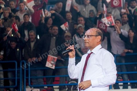 14 décembre 2014 : Au milieu de son speech, deux jeunes femmes sont arrivées sur le podium en ramenant un cadeau au candidat au second tour de l’élection présidentielle une cravate rouge ! Connu pour avoir toujours refusé de porter de cravate, afin de ne pas rompre son élan populiste, Moncef Marzouki a accepté le cadeau des deux jeunes filles et l’a même porté sur le champ. Grand meeting de Moncef Marzouki qui fait salle comble à la coupole de Tunis à une semaine du 2d tour des élections présidentielles. Moncef Marzouki, a appelé ses partisans, « à ne pas tomber dans le piège des insultes et à ne pas dire du mal de son rival Béji Caid Essebsi », tout en affirmant «nous avons le droit de juger cet homme pour son passé et pour son rôle destructeur au cours de la phase transitoire…, mais notre combat est celui des valeurs et l’éthique».Le président sortant et candidat au second tour de la présidentielle a tenu dimanche un meeting au palais des sports d’El Menzah. Ses partisans venus des différentes régions du pays ont scandé des slogans hostiles à son rival Béji Caid Essebsi et à son parti Nidaa Tounes.