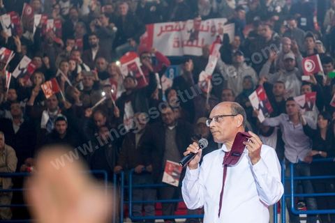 14 décembre 2014 : Au milieu de son speech, deux jeunes femmes sont arrivées sur le podium en ramenant un cadeau au candidat au second tour de l’élection présidentielle une cravate rouge ! Connu pour avoir toujours refusé de porter de cravate, afin de ne pas rompre son élan populiste, Moncef Marzouki a accepté le cadeau des deux jeunes filles et l’a même porté sur le champ. Grand meeting de Moncef Marzouki qui fait salle comble à la coupole de Tunis à une semaine du 2d tour des élections présidentielles. Moncef Marzouki, a appelé ses partisans, « à ne pas tomber dans le piège des insultes et à ne pas dire du mal de son rival Béji Caid Essebsi », tout en affirmant «nous avons le droit de juger cet homme pour son passé et pour son rôle destructeur au cours de la phase transitoire…, mais notre combat est celui des valeurs et l’éthique».Le président sortant et candidat au second tour de la présidentielle a tenu dimanche un meeting au palais des sports d’El Menzah. Ses partisans venus des différentes régions du pays ont scandé des slogans hostiles à son rival Béji Caid Essebsi et à son parti Nidaa Tounes.
