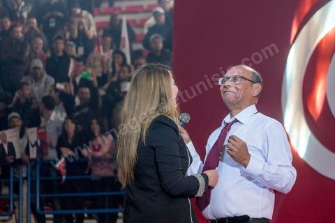 14 décembre 2014 : Au milieu de son speech, deux jeunes femmes sont arrivées sur le podium en ramenant un cadeau au candidat au second tour de l’élection présidentielle une cravate rouge ! Connu pour avoir toujours refusé de porter de cravate, afin de ne pas rompre son élan populiste, Moncef Marzouki a accepté le cadeau des deux jeunes filles et l’a même porté sur le champ. Grand meeting de Moncef Marzouki qui fait salle comble à la coupole de Tunis à une semaine du 2d tour des élections présidentielles. Moncef Marzouki, a appelé ses partisans, « à ne pas tomber dans le piège des insultes et à ne pas dire du mal de son rival Béji Caid Essebsi », tout en affirmant «nous avons le droit de juger cet homme pour son passé et pour son rôle destructeur au cours de la phase transitoire…, mais notre combat est celui des valeurs et l’éthique».Le président sortant et candidat au second tour de la présidentielle a tenu dimanche un meeting au palais des sports d’El Menzah. Ses partisans venus des différentes régions du pays ont scandé des slogans hostiles à son rival Béji Caid Essebsi et à son parti Nidaa Tounes.