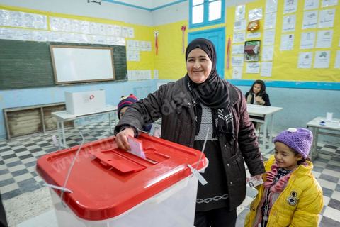 21 décembre 2014 : Accompagnée de ses enfants, une habitante accomplit son devoir civique. jour de vote pour le second tour des élections présidentielles opposant Beji Caid Essebsi, favori,  au président sortant Moncef Marzouki.