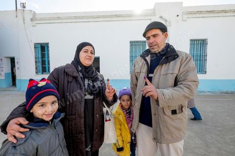 21 décembre 2014 : Accompagnée de ses enfants, une habitante accomplit son devoir civique. jour de vote pour le second tour des élections présidentielles opposant Beji Caid Essebsi, favori,  au président sortant Moncef Marzouki.