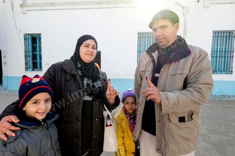21 décembre 2014 : Accompagnée de ses enfants, une habitante accomplit son devoir civique. jour de vote pour le second tour des élections présidentielles opposant Beji Caid Essebsi, favori,  au président sortant Moncef Marzouki.