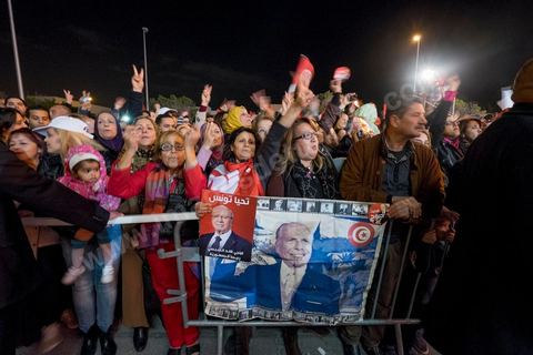 21 décembre 2014 : Militant avec portrait historique de Habib Bourguiba et de Béji Caid Essebsi. Dès la fin du scrutin à 18h, les rumeurs d'une large victoire de Beji Caïd Essebsi, candidat du parti Nidaa Tounes, circulent. Avec 8 à 10 points d'avance selon les sondages, Béji Caid Essebsi remporte les 1ères élections présidentielles libres en Tunisie depuis la révolution de 2011. A cette annonce les militants sont venus nombreux féter la victoire annoncée devant le QG de campagne du parti dans le quartier très huppé des Berges du Lac de Tunis.