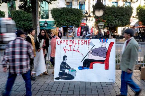 14 janvier 2015 : Une dizaine de membres du parti socialiste brandissaient quelques pancartes anticapitalistes. Les Tunisiens célèbrent sur l'avenue Habib Bourguiba à Tunis le 4ème anniversaire de la révolution tunisienne qui a mené à la chute du président déchu Zine el Abdidine Ben Ali, le vendredi 14 janvier 2011 et son exil vers l’Arabie Saoudite. Entre les nombreux tunisiens venus marcher en famille sous un doux soleil, des regroupements très variés se répartissés l'avenue, famille de martyrs, partisans d'Hizbt Tahrir, d'Ennahdha ou d'El Watan, jeunesse islamiste des LPR, soutien à Sofiane et Nadhir, ...
