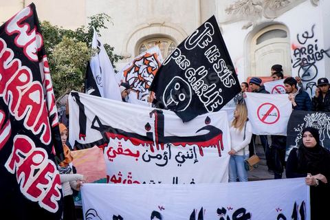 January 14, 2015: About 50 young Islamists from the Kram League for the Protection of the Revolution came to wave banners reading “I am not Charlie” or “I am Muhammad.” Tunisians gathered on Habib Bourguiba Avenue in Tunis to celebrate the fourth anniversary of the Tunisian revolution, which led to the ouster of former President Zine el Abdidine Ben Ali on Friday, January 14, 2011, and his exile to Saudi Arabia. Among the many Tunisians who came to march with their families under mild sunshine, a wide variety of groups were scattered along the avenue: families of martyrs, supporters of Hizb ut-Tahrir, Ennahda, or El Watan, Islamist youth from the LPR, and supporters of Sofiane and Nadhir, ...