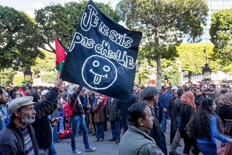 January 14, 2015: About 50 young Islamists from the Kram League for the Protection of the Revolution came to wave banners reading “I am not Charlie” or “I am Muhammad.” Tunisians gathered on Habib Bourguiba Avenue in Tunis to celebrate the fourth anniversary of the Tunisian revolution, which led to the ouster of former President Zine el Abdidine Ben Ali on Friday, January 14, 2011, and his exile to Saudi Arabia. Among the many Tunisians who came to march with their families under mild sunshine, a wide variety of groups were scattered along the avenue: families of martyrs, supporters of Hizb ut-Tahrir, Ennahda, or El Watan, Islamist youth from the LPR, and supporters of Sofiane and Nadhir, ...
