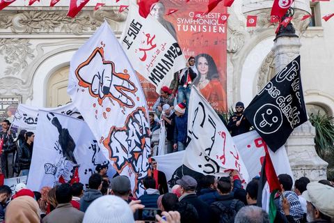 January 14, 2015: About 50 young Islamists from the Kram League for the Protection of the Revolution came to wave banners reading “I am not Charlie” or “I am Muhammad.” Tunisians gathered on Habib Bourguiba Avenue in Tunis to celebrate the fourth anniversary of the Tunisian revolution, which led to the ouster of former President Zine el Abdidine Ben Ali on Friday, January 14, 2011, and his exile to Saudi Arabia. Among the many Tunisians who came to march with their families under mild sunshine, a wide variety of groups were scattered along the avenue: families of martyrs, supporters of Hizb ut-Tahrir, Ennahda, or El Watan, Islamist youth from the LPR, and supporters of Sofiane and Nadhir, ...