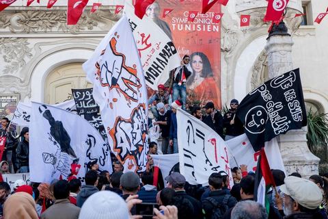 January 14, 2015: About 50 young Islamists from the Kram League for the Protection of the Revolution came to wave banners reading “I am not Charlie” or “I am Muhammad.” Tunisians gathered on Habib Bourguiba Avenue in Tunis to celebrate the fourth anniversary of the Tunisian revolution, which led to the ouster of former President Zine el Abdidine Ben Ali on Friday, January 14, 2011, and his exile to Saudi Arabia. Among the many Tunisians who came to march with their families under mild sunshine, a wide variety of groups were scattered along the avenue: families of martyrs, supporters of Hizb ut-Tahrir, Ennahda, or El Watan, Islamist youth from the LPR, and supporters of Sofiane and Nadhir, ...