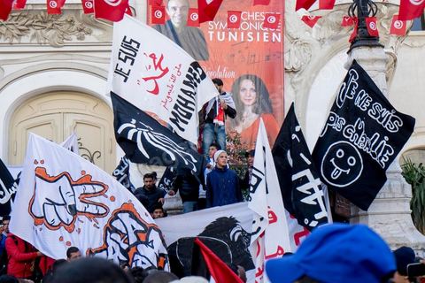 January 14, 2015: About 50 young Islamists from the Kram League for the Protection of the Revolution came to wave banners reading “I am not Charlie” or “I am Muhammad.” Tunisians gathered on Habib Bourguiba Avenue in Tunis to celebrate the fourth anniversary of the Tunisian revolution, which led to the ouster of former President Zine el Abdidine Ben Ali on Friday, January 14, 2011, and his exile to Saudi Arabia. Among the many Tunisians who came to march with their families under mild sunshine, a wide variety of groups were scattered along the avenue: families of martyrs, supporters of Hizb ut-Tahrir, Ennahda, or El Watan, Islamist youth from the LPR, and supporters of Sofiane and Nadhir, ...