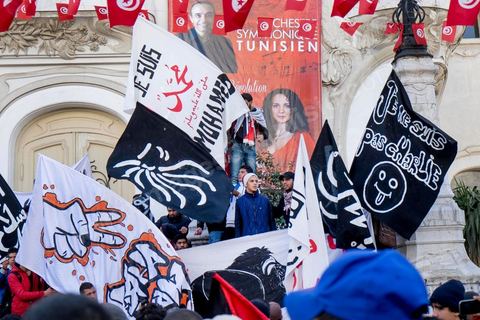 January 14, 2015: About 50 young Islamists from the Kram League for the Protection of the Revolution came to wave banners reading “I am not Charlie” or “I am Muhammad.” Tunisians gathered on Habib Bourguiba Avenue in Tunis to celebrate the fourth anniversary of the Tunisian revolution, which led to the ouster of former President Zine el Abdidine Ben Ali on Friday, January 14, 2011, and his exile to Saudi Arabia. Among the many Tunisians who came to march with their families under mild sunshine, a wide variety of groups were scattered along the avenue: families of martyrs, supporters of Hizb ut-Tahrir, Ennahda, or El Watan, Islamist youth from the LPR, and supporters of Sofiane and Nadhir, ...
