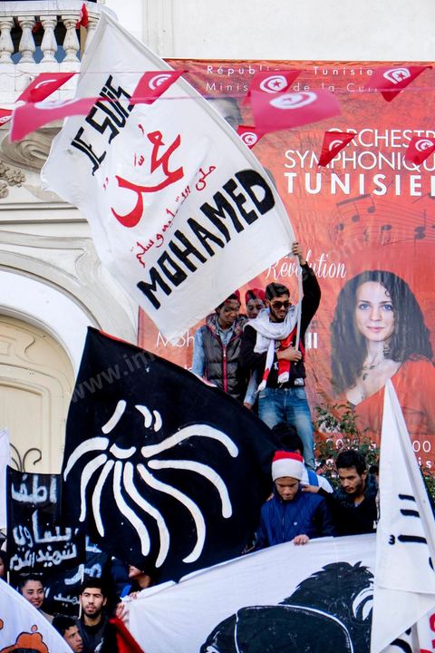January 14, 2015: About 50 young Islamists from the Kram League for the Protection of the Revolution came to wave banners reading “I am not Charlie” or “I am Muhammad.” Tunisians gathered on Habib Bourguiba Avenue in Tunis to celebrate the fourth anniversary of the Tunisian revolution, which led to the ouster of former President Zine el Abdidine Ben Ali on Friday, January 14, 2011, and his exile to Saudi Arabia. Among the many Tunisians who came to march with their families under mild sunshine, a wide variety of groups were scattered along the avenue: families of martyrs, supporters of Hizb ut-Tahrir, Ennahda, or El Watan, Islamist youth from the LPR, and supporters of Sofiane and Nadhir, ...