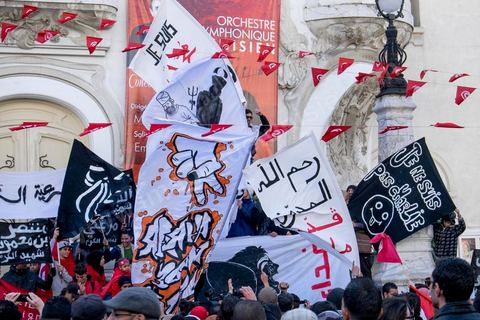 January 14, 2015: About 50 young Islamists from the Kram League for the Protection of the Revolution came to wave banners reading “I am not Charlie” or “I am Muhammad.” Tunisians gathered on Habib Bourguiba Avenue in Tunis to celebrate the fourth anniversary of the Tunisian revolution, which led to the ouster of former President Zine el Abdidine Ben Ali on Friday, January 14, 2011, and his exile to Saudi Arabia. Among the many Tunisians who came to march with their families under mild sunshine, a wide variety of groups were scattered along the avenue: families of martyrs, supporters of Hizb ut-Tahrir, Ennahda, or El Watan, Islamist youth from the LPR, and supporters of Sofiane and Nadhir, ...