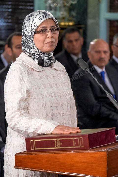 6 février 2015 : Amel Azzouz, du parti Ennahdha, secrétaire d’Etat chargée de la Coopération internationale prête serment sur le Coran. Deux jours après le vote de confiance du nouveau gouvernement de Habib Essid à l'assemblée avec une large majorité pour de 166 sièges sur 217, cérémonie de pretsation de serment et photo du nouveau gouvernement au Palais de Carthage autour du Président de la République Béji Caïd Essebsi. Les 44 ministres et secrétaires d’Etat choisis par le Chef du gouvernement Habib Essid se sont présentés, chacun son tour, devant le président de la République pour prêter serment sur le Coran. 