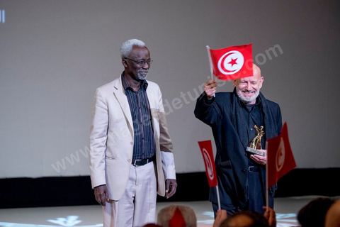 November 28, 2015: Tribute and honorary award presented to Tunisian filmmaker Nouri Bouzid by Souleymane Cissé. Closing ceremony of the JCC at the Municipal Theater of Tunis, in the heart of the capital, which had been devastated just a few days earlier by a suicide terrorist attack that killed 12 members of the presidential guard. The ceremony, moved up due to a curfew, served as a tribute to the culture that stood up to terror throughout the week and provided an opportunity to honor artists and filmmakers from the Arab-African world. 