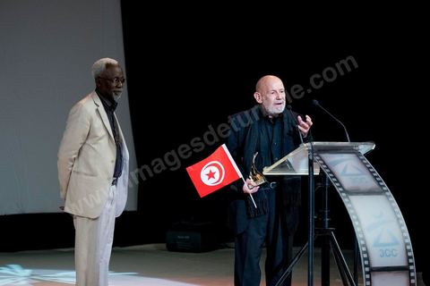 November 28, 2015: Tribute and honorary award presented to Tunisian filmmaker Nouri Bouzid by Souleymane Cissé. Closing ceremony of the JCC at the Municipal Theater of Tunis, in the heart of the capital, which had been devastated just a few days earlier by a suicide terrorist attack that killed 12 members of the presidential guard. The ceremony, moved up due to a curfew, served as a tribute to the culture that stood up to terror throughout the week and provided an opportunity to honor artists and filmmakers from the Arab-African world. 