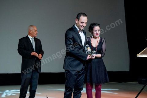 November 28, 2015: Houcine Abbassi presents the UGTT Award to Leyla Bouzid, a young Tunisian filmmaker who has received several awards—including the Bronze Tanit, the FIPRESCI Award, a Special Mention from the UGTT Jury, and the TV5 Monde Jury Prize—for her film “As Soon as I Open My Eyes.” The closing ceremony of the JCC took place at the Municipal Theater of Tunis, in the heart of the capital, which had been devastated just a few days earlier by a suicide terrorist attack that killed 12 members of the Presidential Guard. The ceremony, moved up due to a curfew, served as a tribute to culture—which stood firm in the face of terror throughout the week—and provided an opportunity to honor artists and filmmakers from the Arab-African world. 