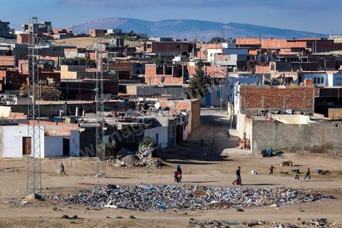 January 22, 2016: Between the famous working-class and revolutionary neighborhoods of Ezzouhour and Ennour on the hills above Kasserine, the neighborhoods continue to grow in a haphazard manner. The Karma neighborhood is one of the most deprived; its residents live amid piles of trash, and some are still waiting to be connected to the water supply. In the distance, Mount Chambi dominates the horizon, serving as a reminder of the presence and danger of terrorism.